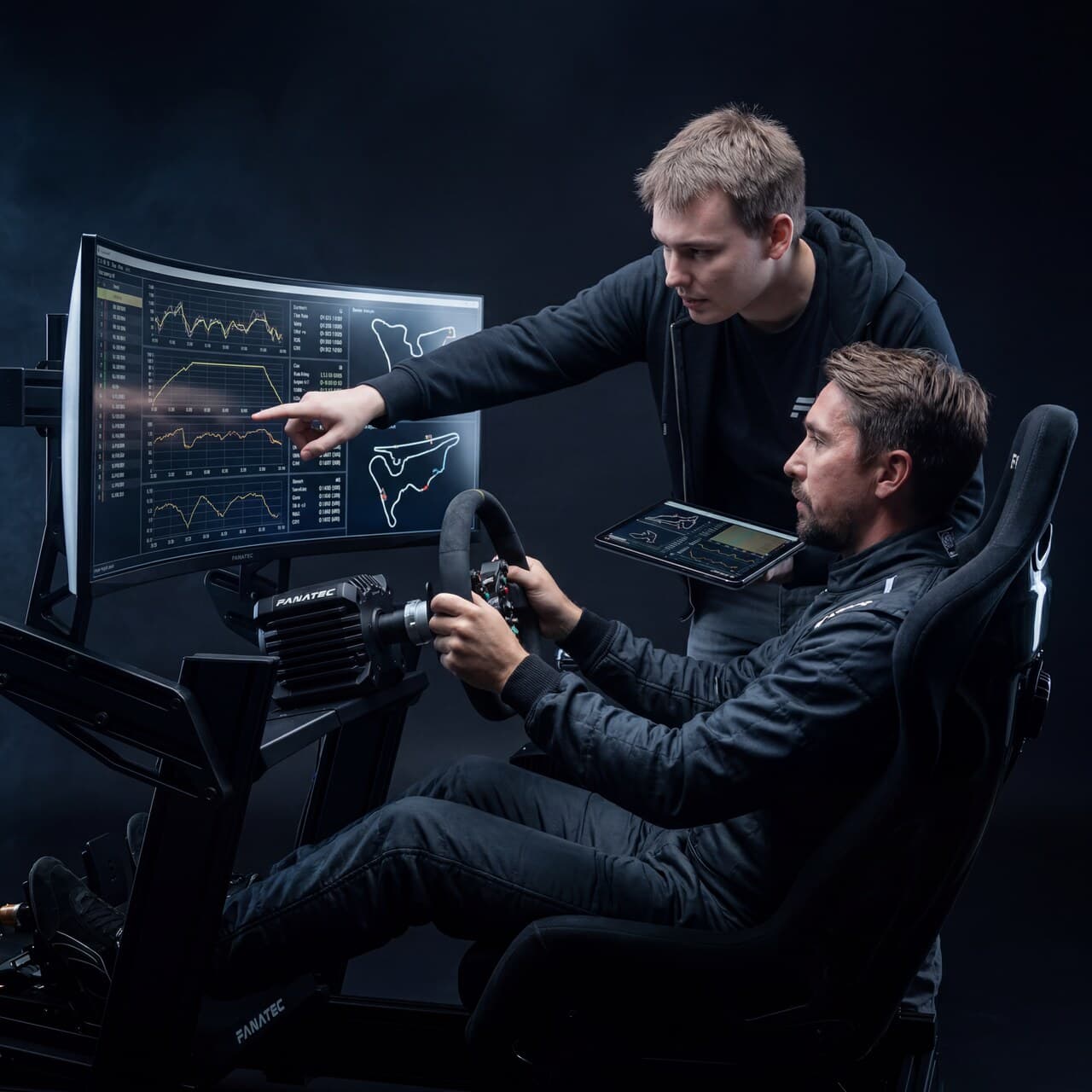 Treinador apontando dados de telemetria para um piloto em um cockpit de sim racing